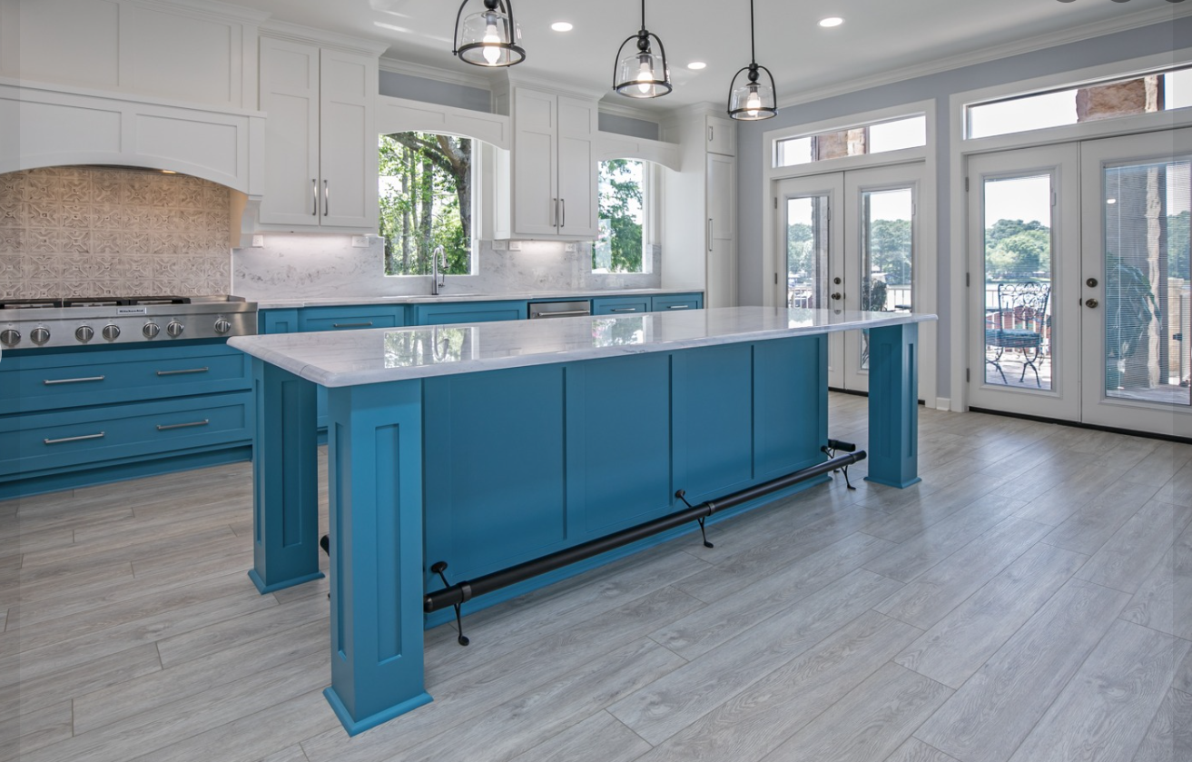 A kitchen with blue cabinets and white counter tops.