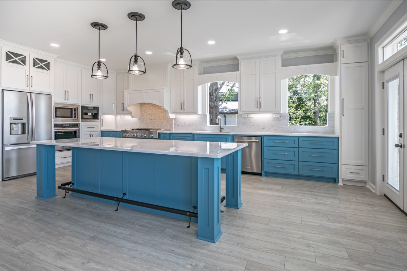 A kitchen with blue cabinets and a large island in the middle.