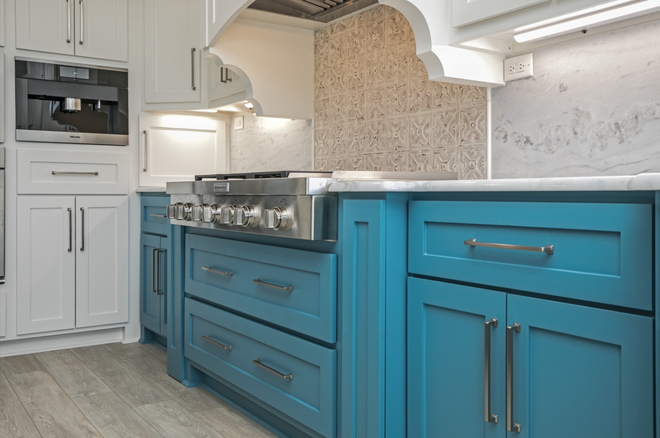 A kitchen with blue cabinets and a stove top oven.