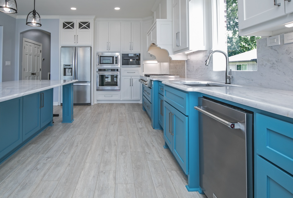 A kitchen with blue cabinets and white counter tops