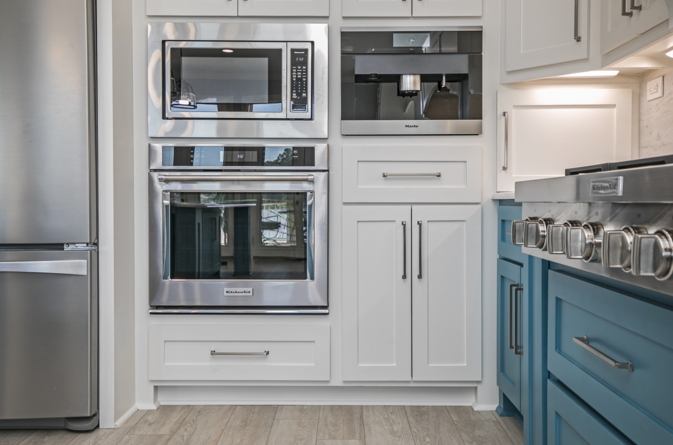 A kitchen with stainless steel appliances and blue cabinets.