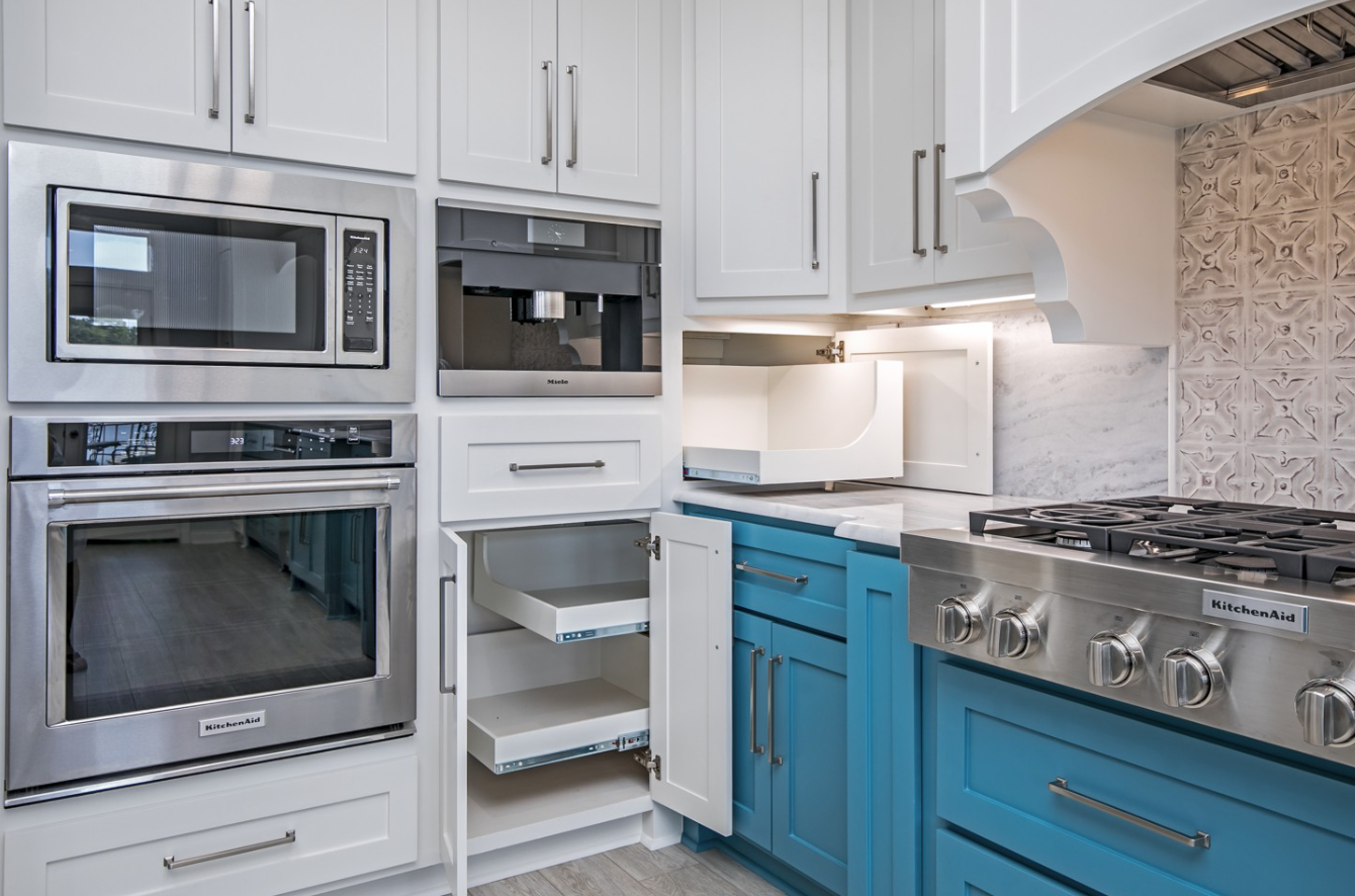 A kitchen with blue cabinets and stainless steel appliances.