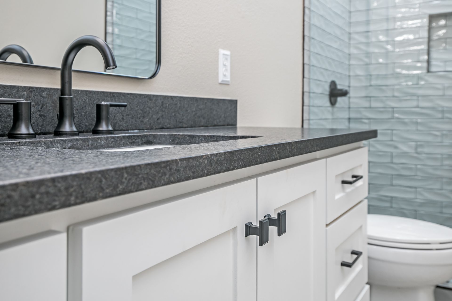 A bathroom with two sinks , a toilet and a mirror.