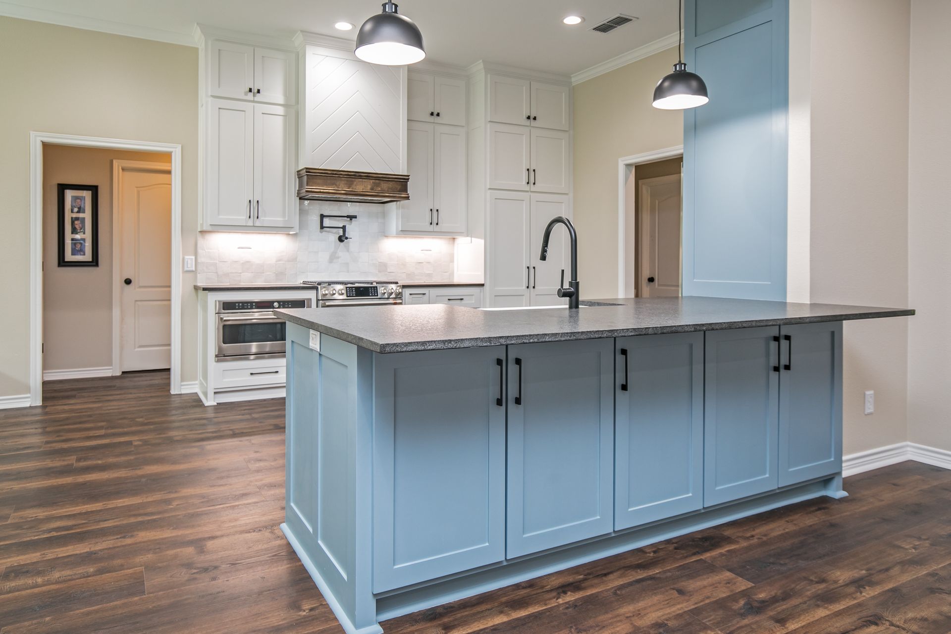 A kitchen with blue cabinets and a large island in the middle.