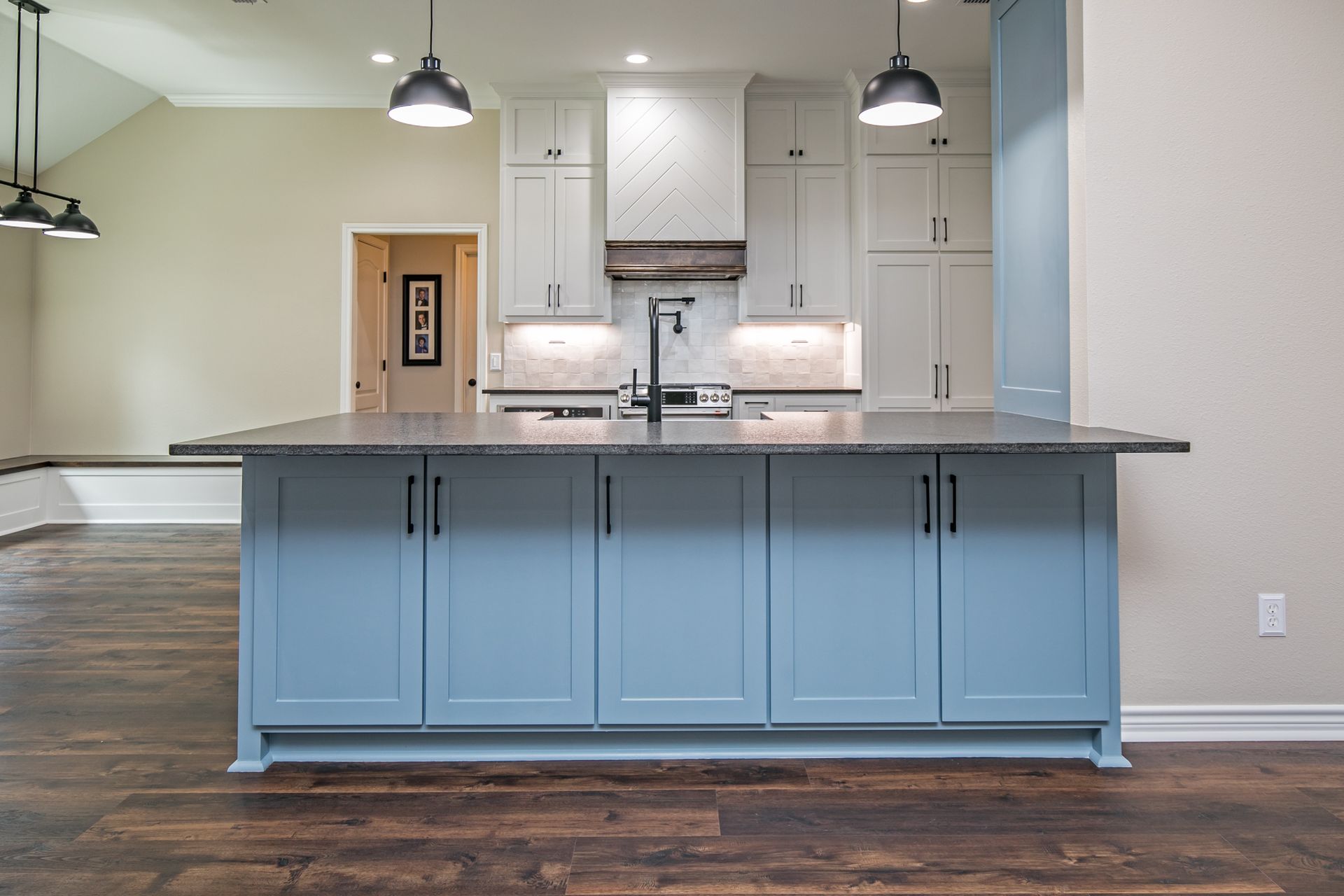 A kitchen with blue cabinets and a large island in the middle.