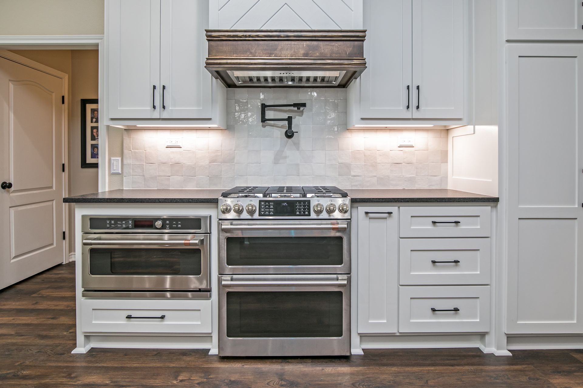 A kitchen with white cabinets and stainless steel appliances.