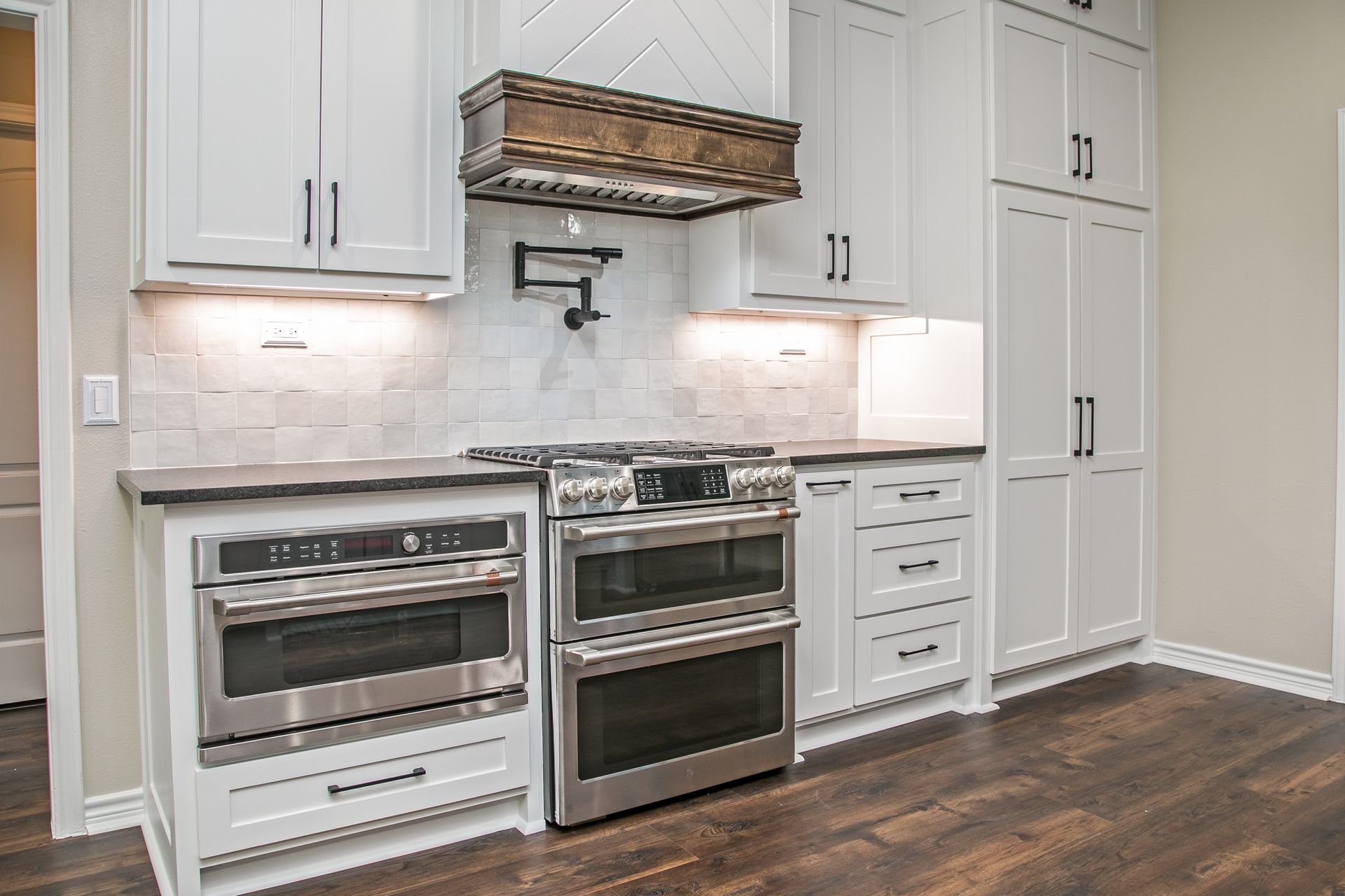 A kitchen with white cabinets and stainless steel appliances.