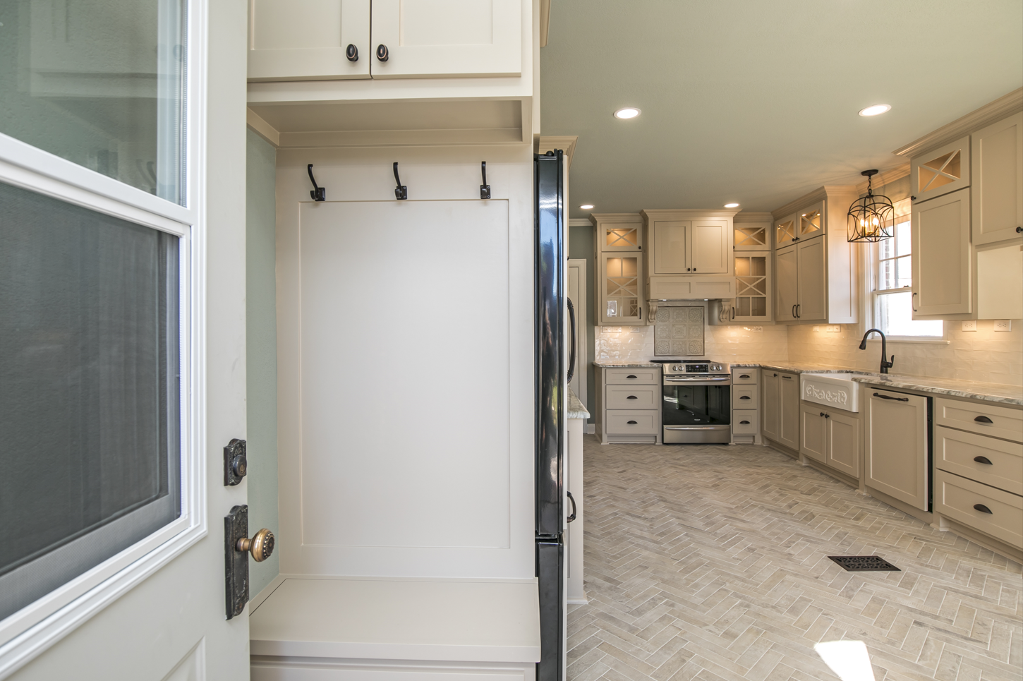 A kitchen with white cabinets and a stainless steel refrigerator.