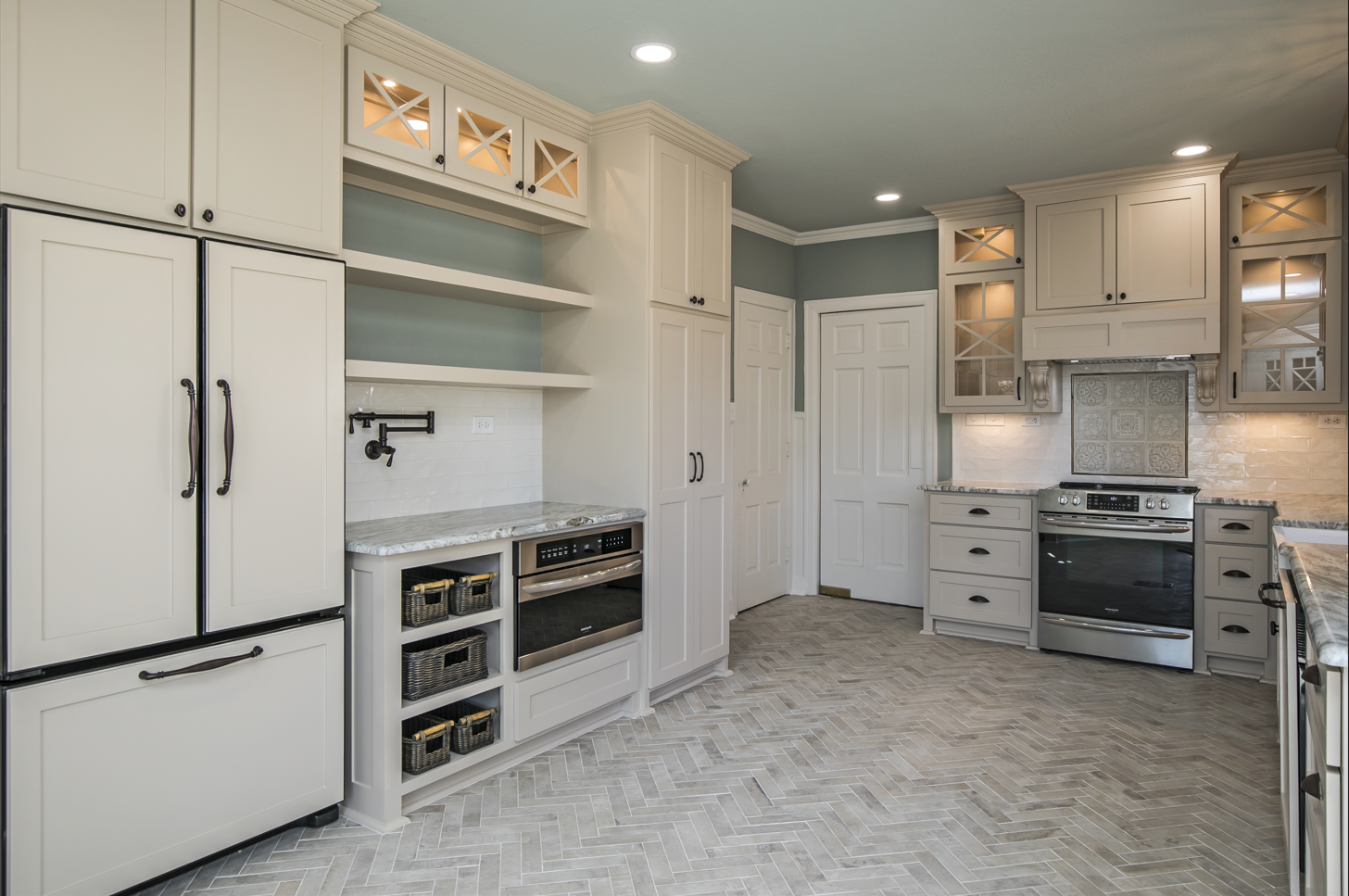 A kitchen with white cabinets , stainless steel appliances , and granite counter tops.