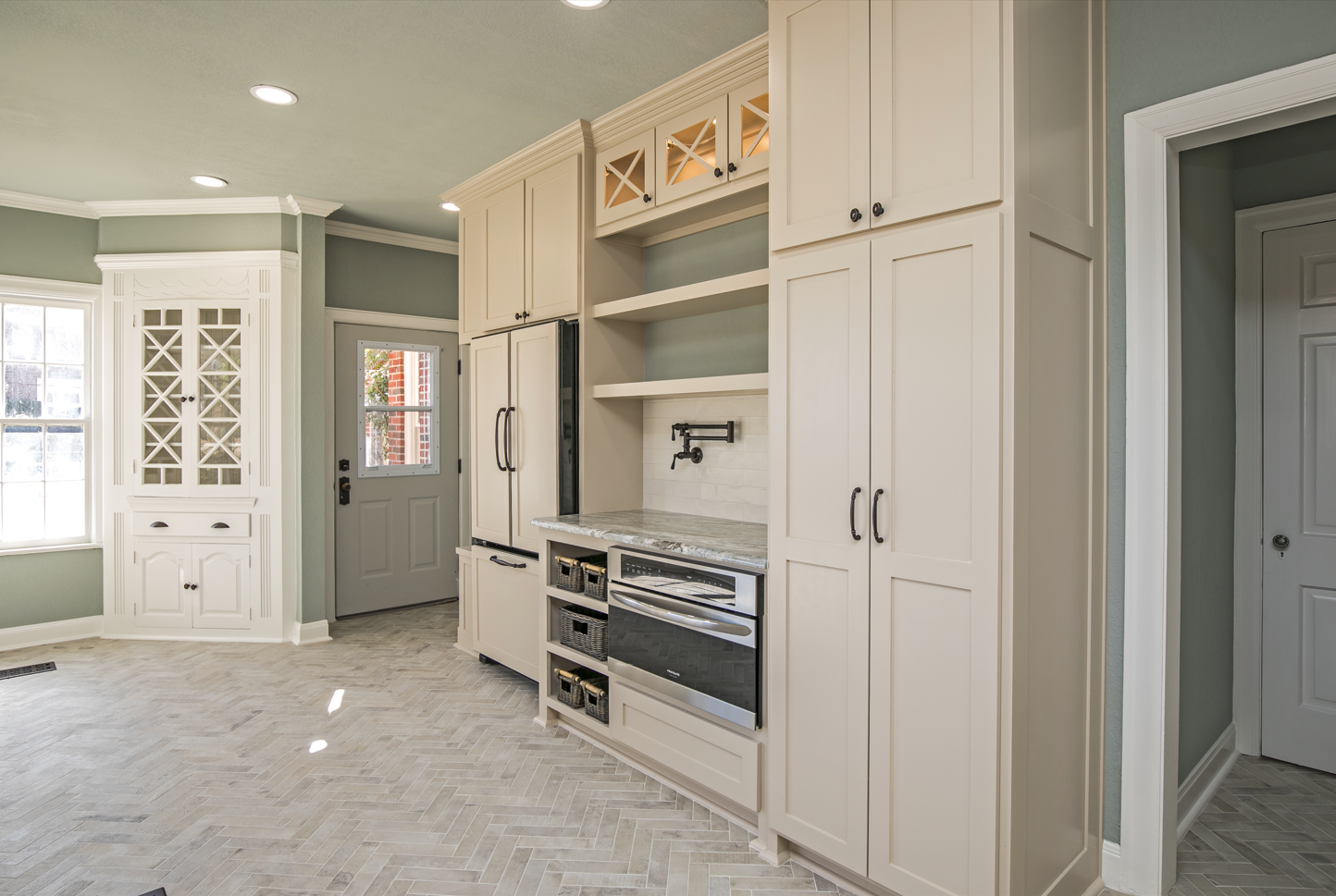 A kitchen with white cabinets and stainless steel appliances.