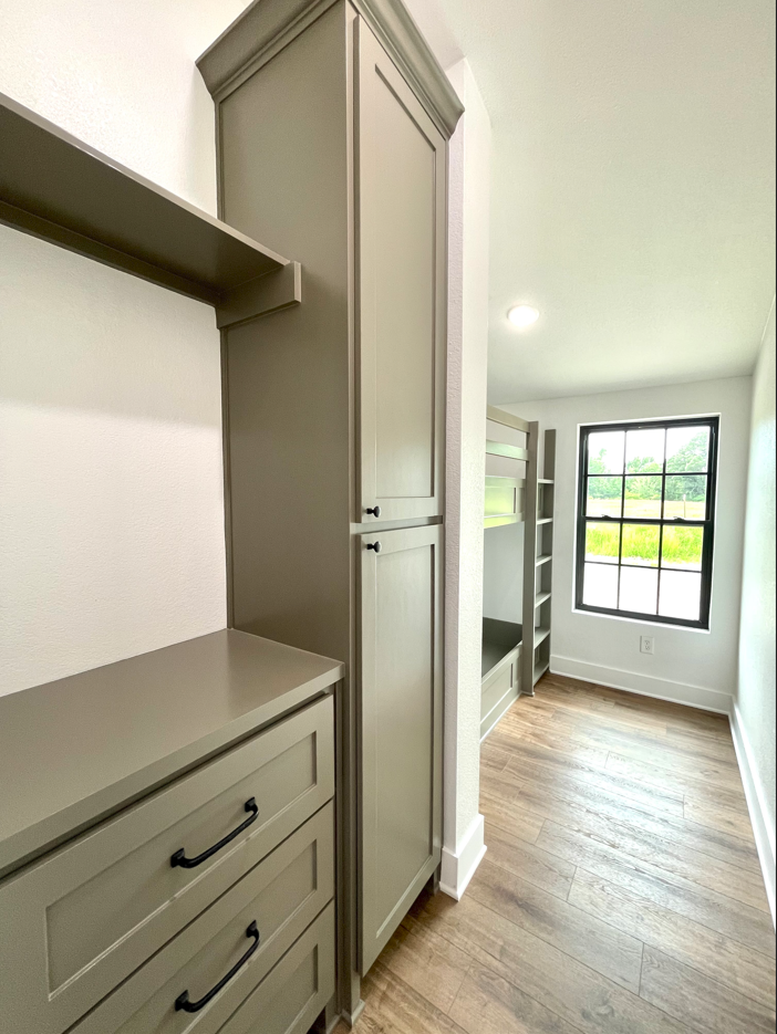 A bedroom with a bunk bed , dresser , and window.