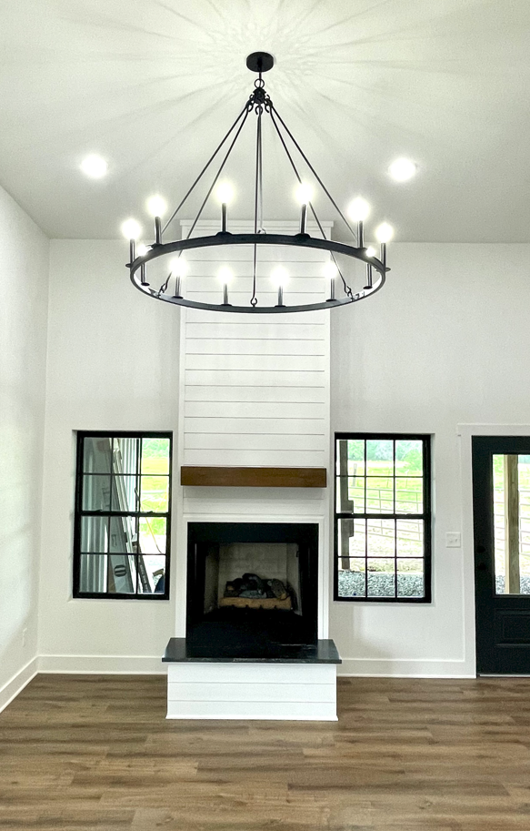 A living room with a fireplace and a chandelier hanging from the ceiling.