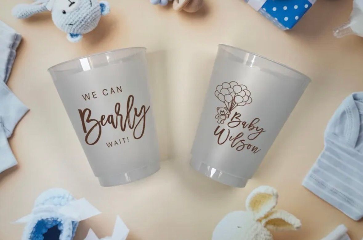 Two frosted plastic cups with baby shower text and decorations.