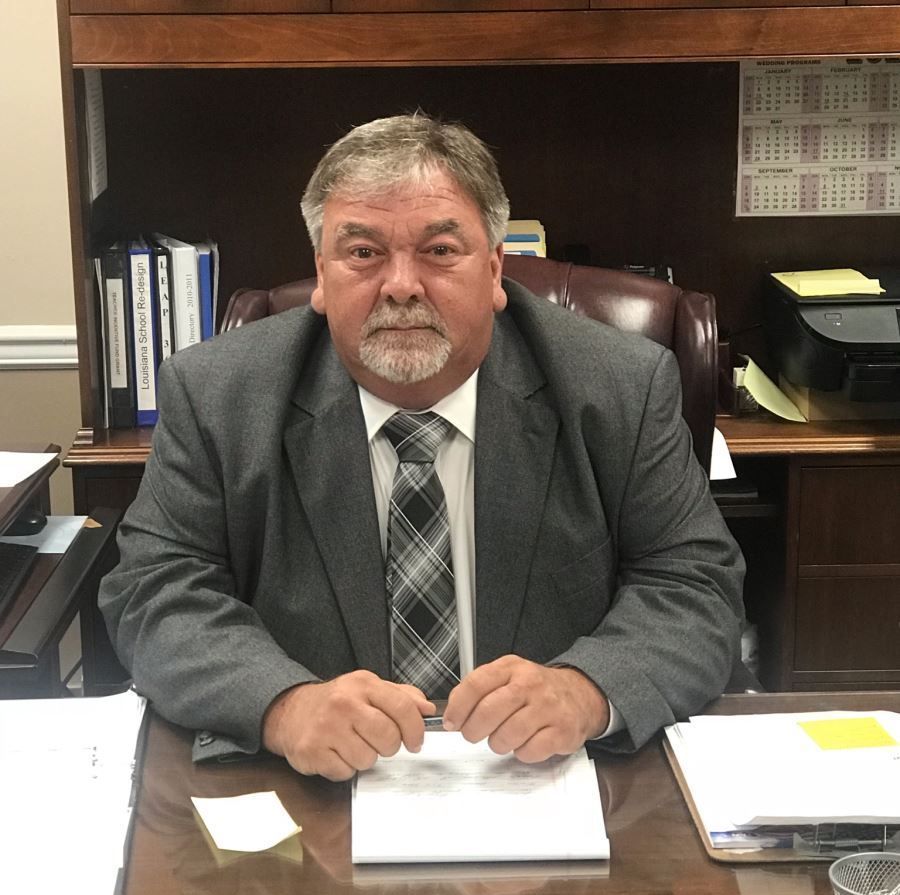 A man in a suit and tie is sitting at a desk