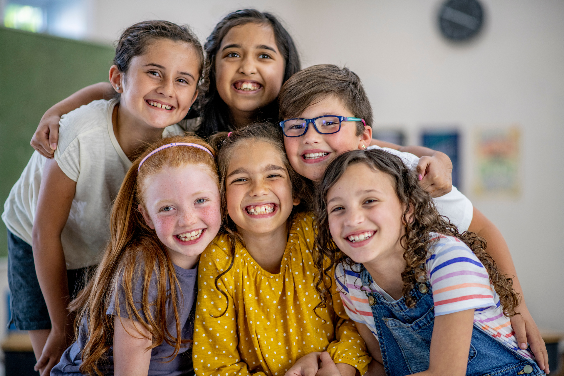 A group of children are posing for a picture in a classroom.