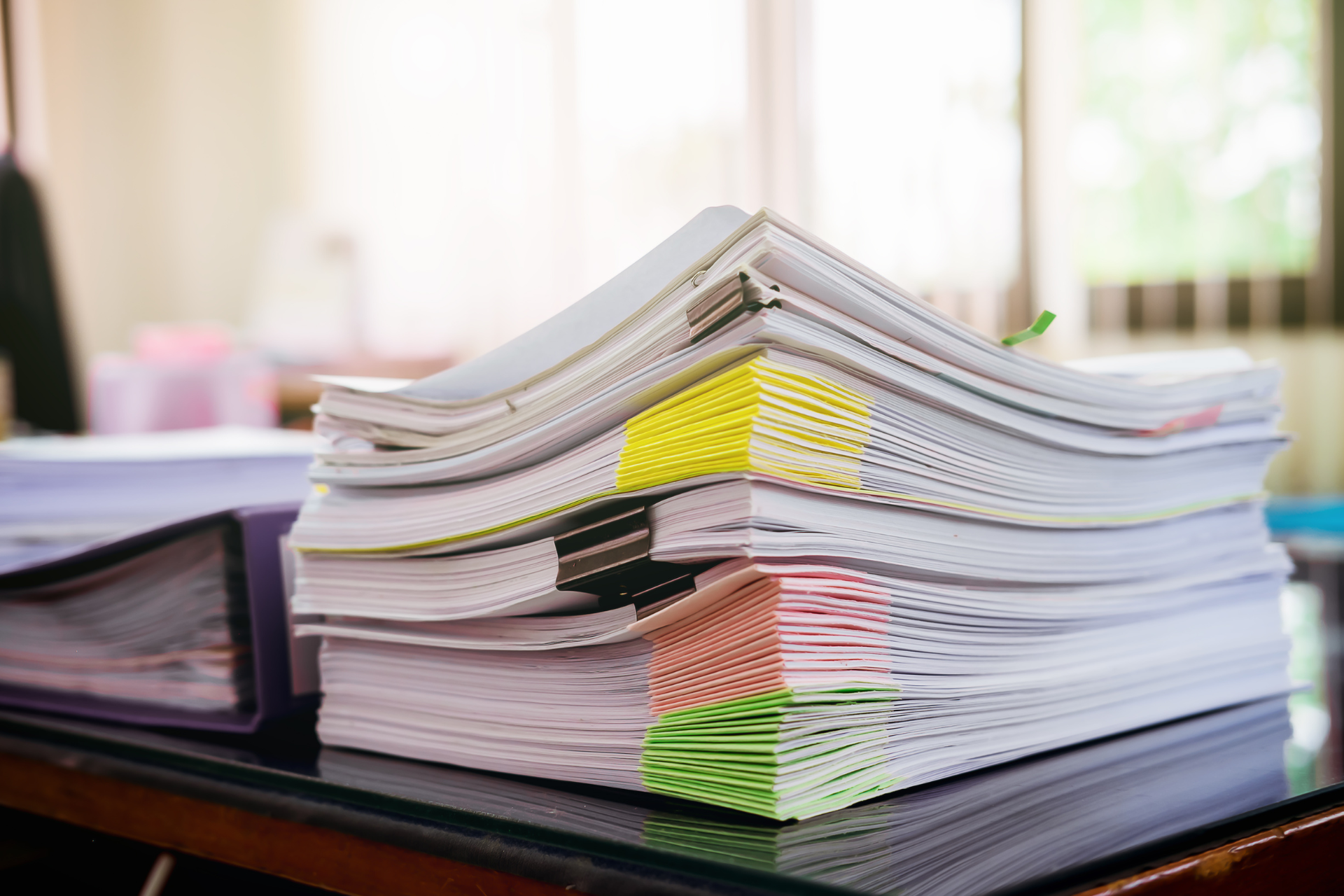 A stack of papers is sitting on top of a desk.