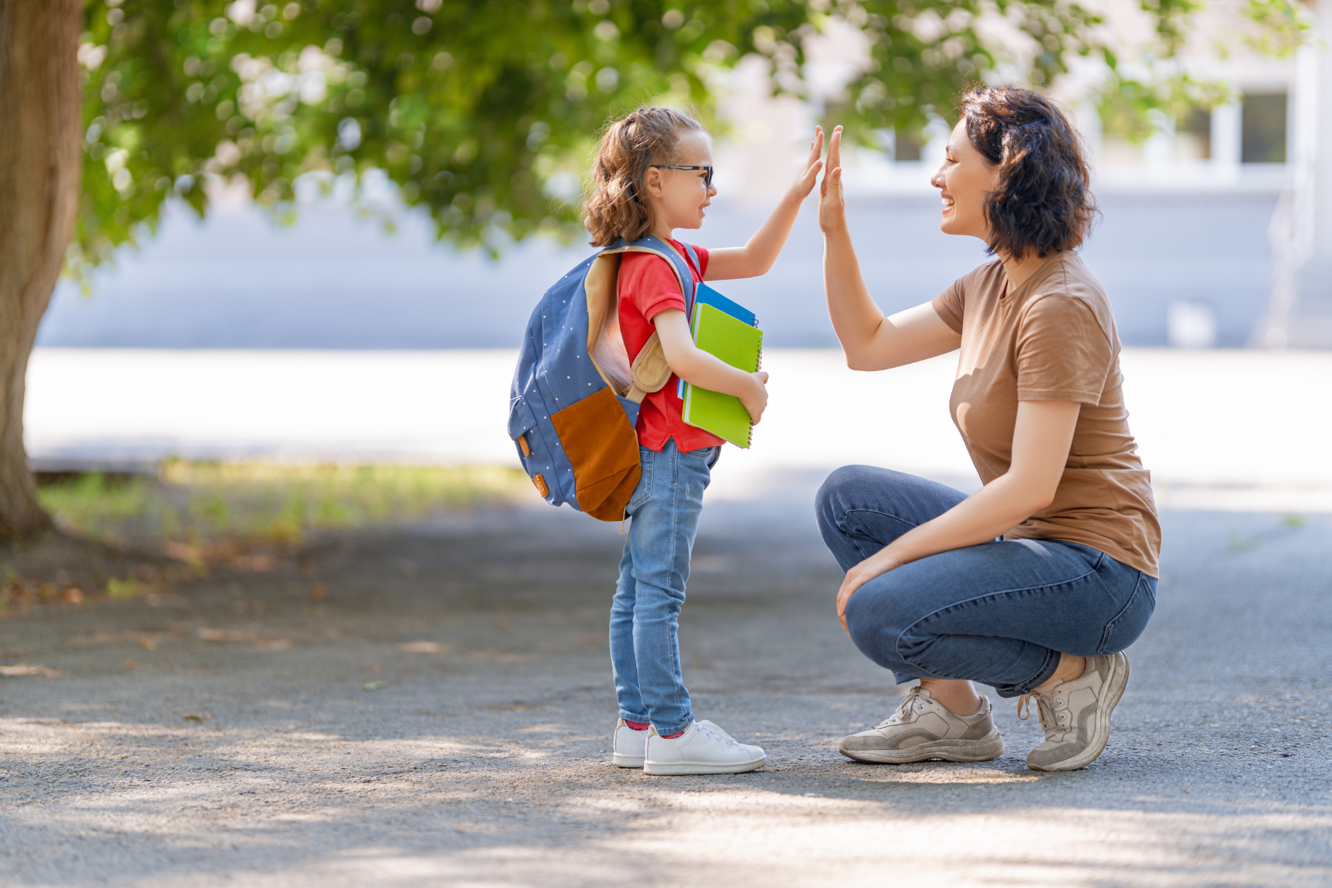 A woman and a little girl are giving each other a high five.