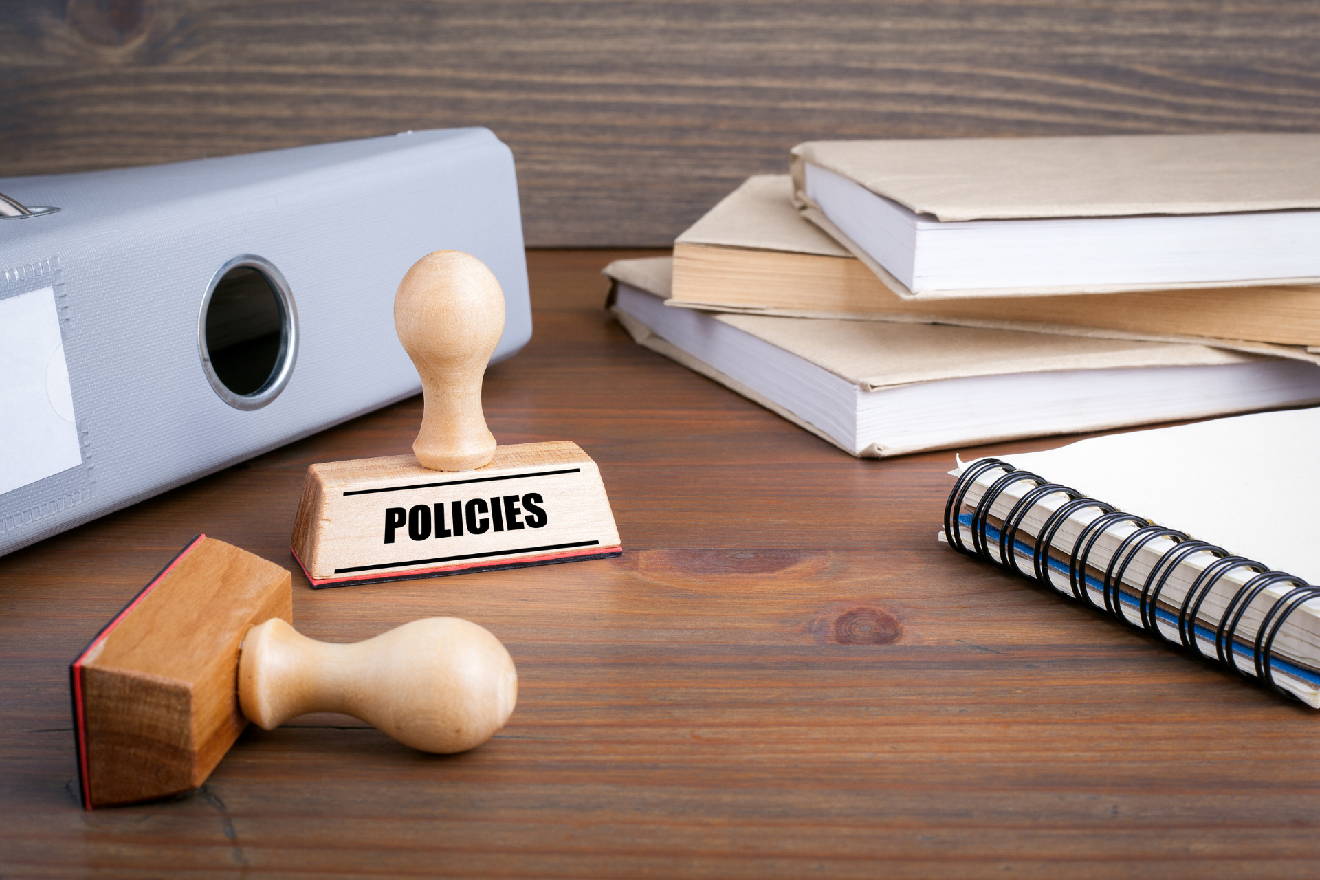 A wooden stamp with the word policies written on it.