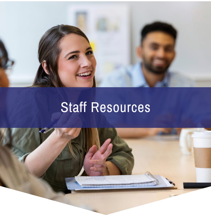 A group of people are sitting at a table with a sign that says staff resources