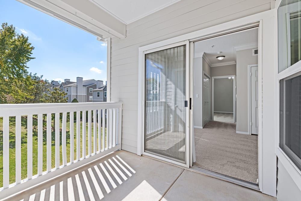 Apartment balcony with sliding glass doors and a white railing at Marquis at Silverton in Cary, NC.