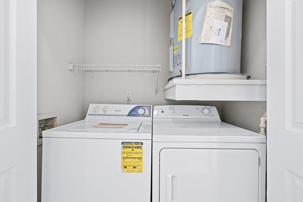 A laundry room with a washer and dryer and a water heater at Marquis at Silverton in Cary, NC.