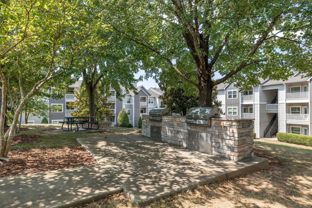 A picnic table in the middle with grilling stations on the side at Marquis at Silverton in Cary, NC.
