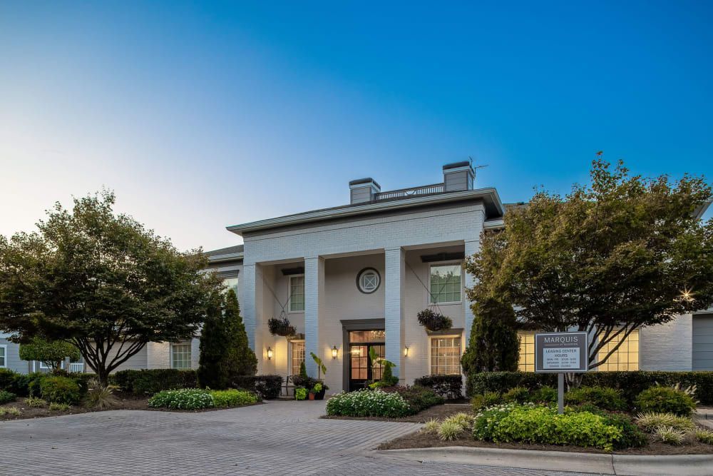 A large white building with a lot of windows and trees in front of it at Marquis at Silverton in Cary, NC.