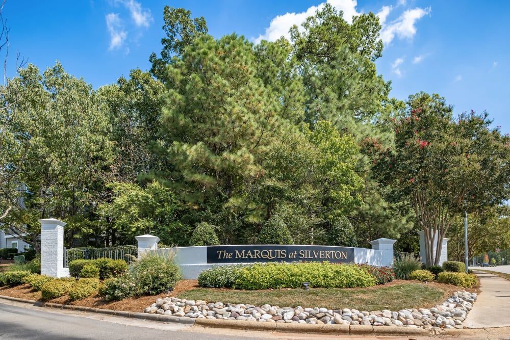 Apartment signage with trees in the background at Marquis at Silverton in Cary, NC.