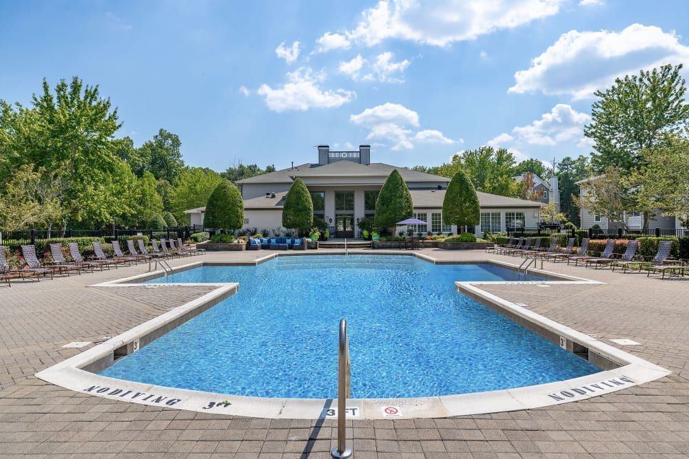 Outdoor swimming pool with the clubhouse building in the background at Marquis at Silverton in Cary, NC.