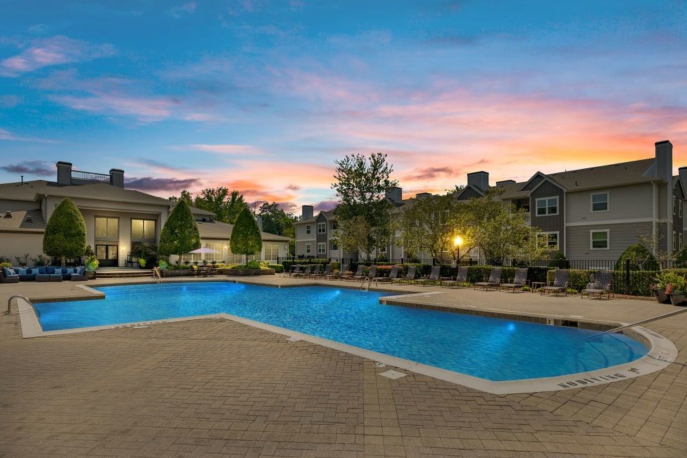 Outdoor swimming pool in front of a building at sunset at Marquis at Silverton in Cary, NC.