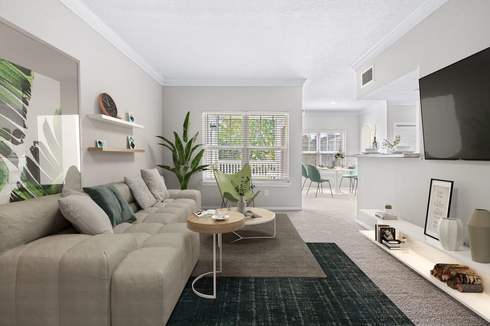 Apartment living room with a couch, table, and television at Marquis at Silverton in Cary, NC.