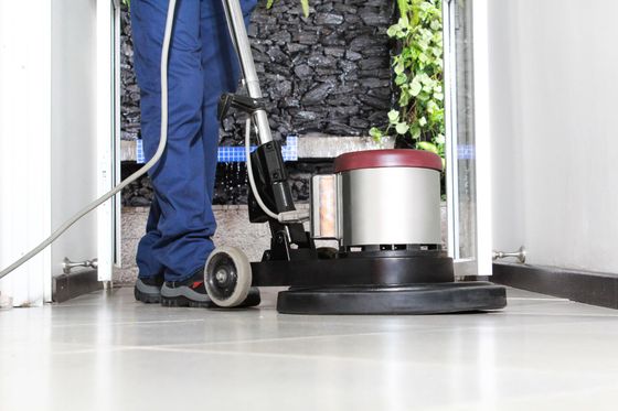 A person is using a machine to clean a tile floor.