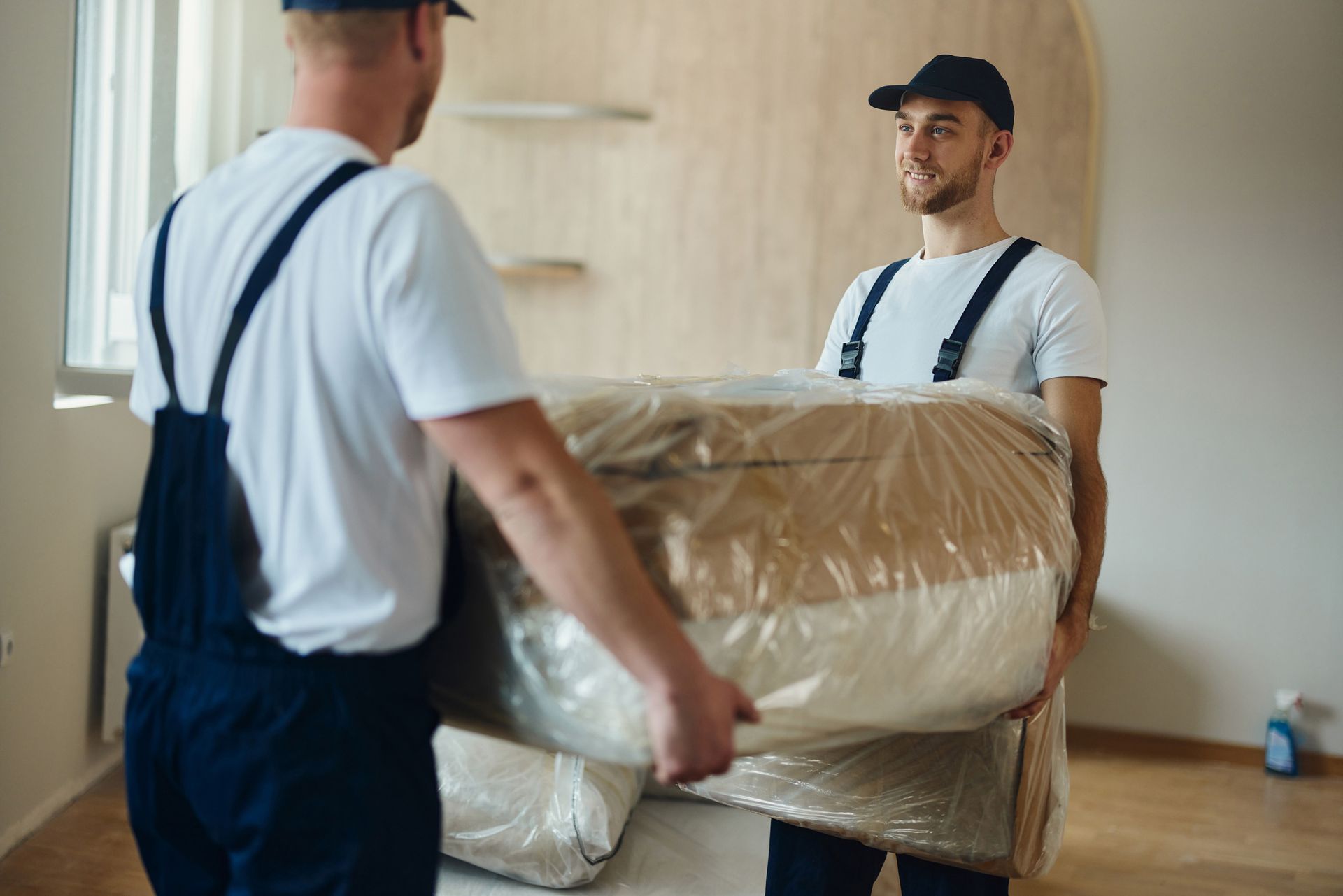 Two male movers working together carrying furniture, showcasing expert residential moving services.