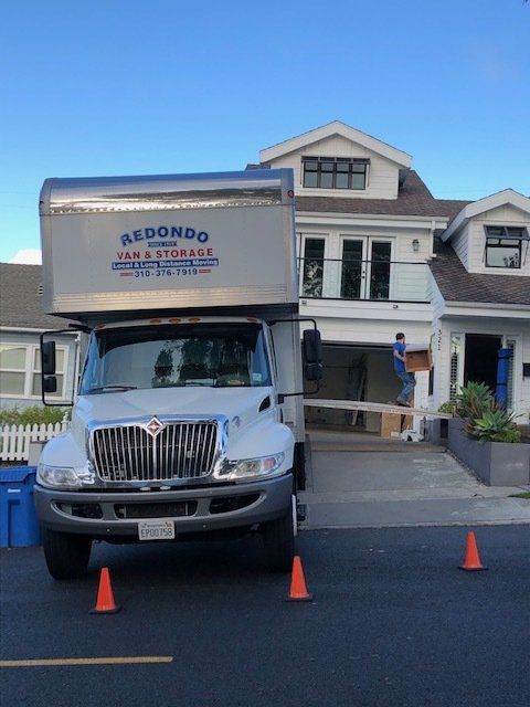 Two male movers working together carrying furniture, showcasing expert residential moving services.