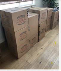 Stacked moving boxes in a sunlit room, ready for transport and storage.