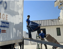 The moving crew transports boxes from the curbside truck to the home entrance.