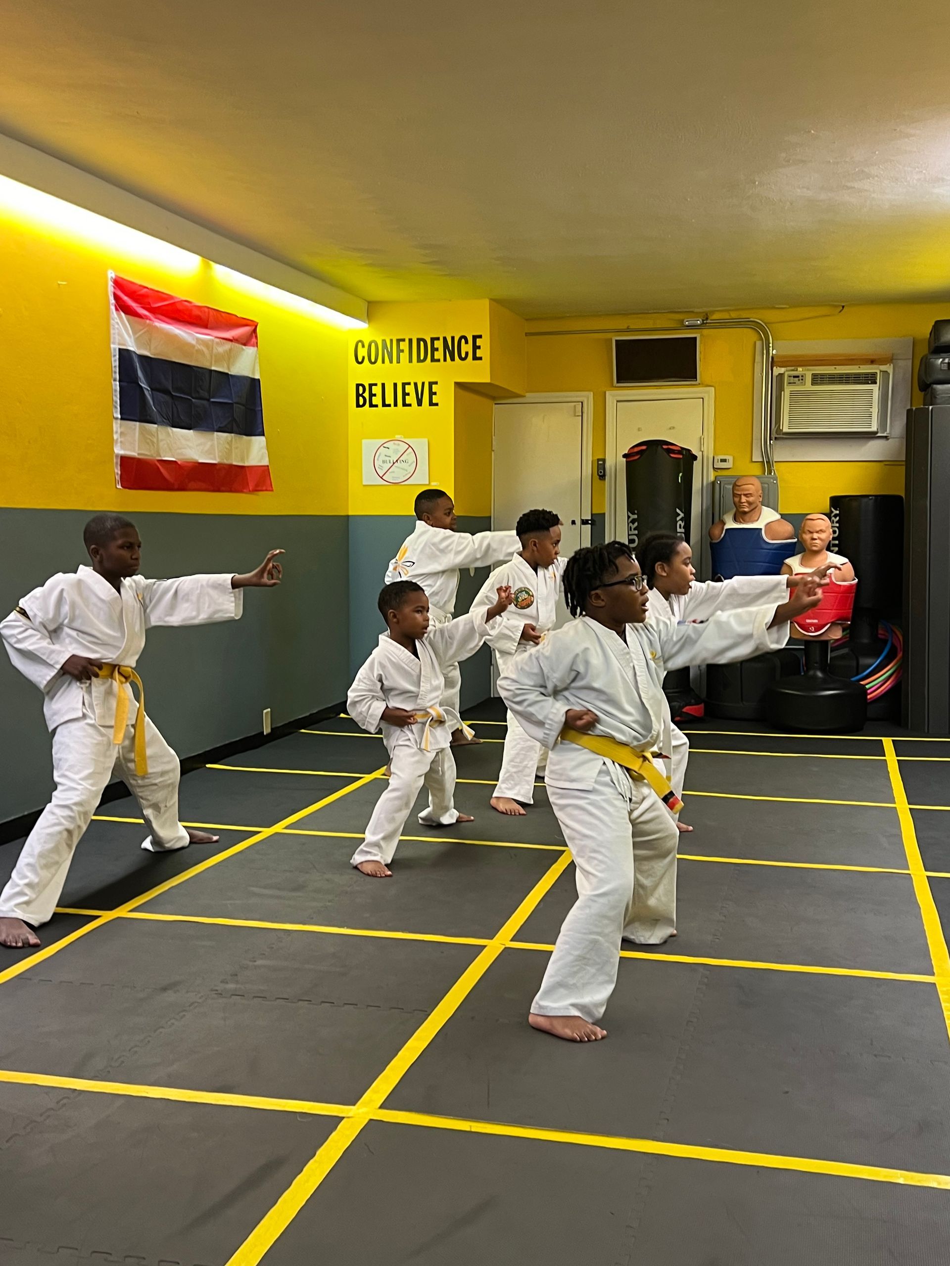A group of young boys are practicing karate in a gym.