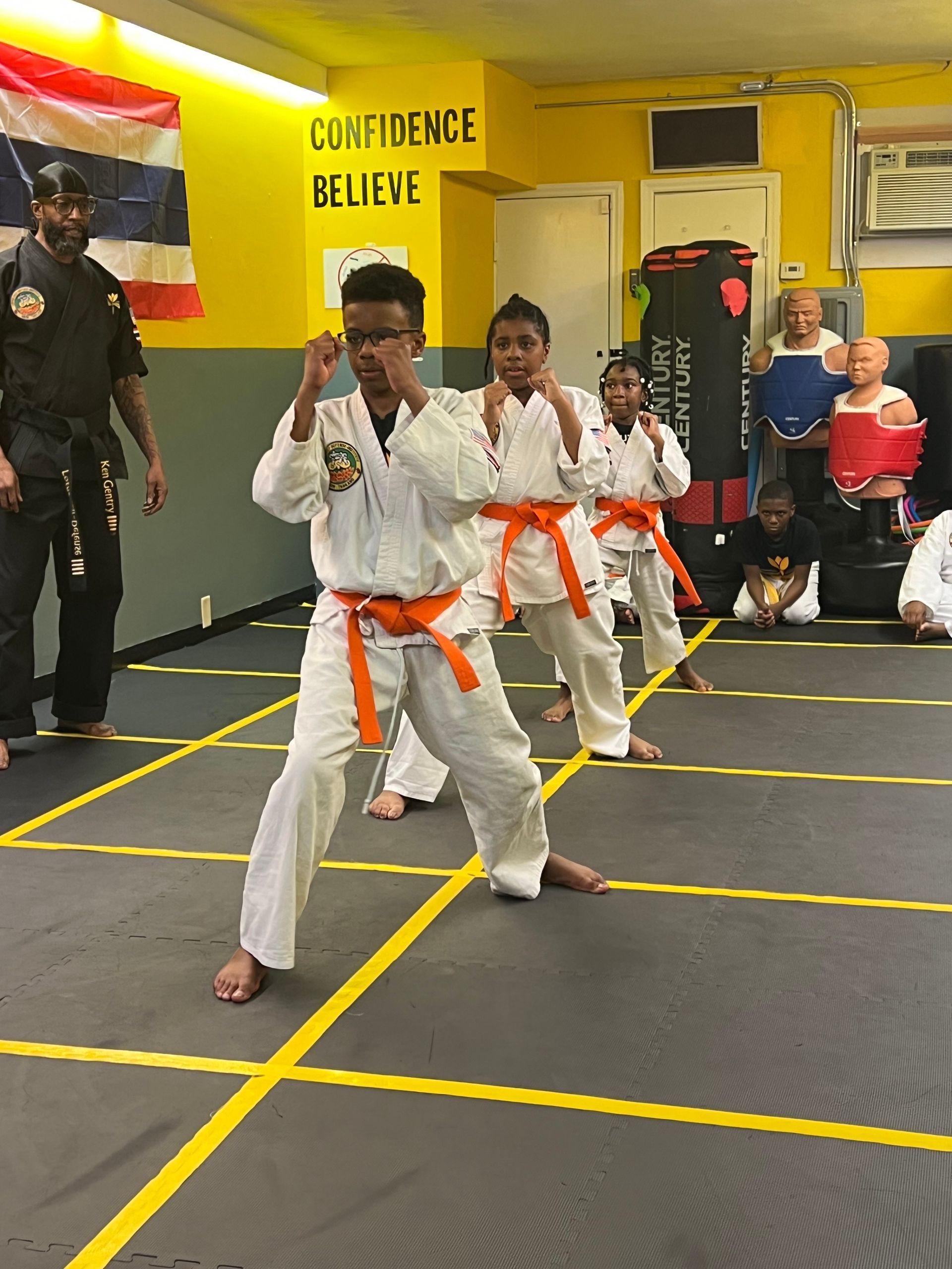 A group of young boys are practicing martial arts in a gym.