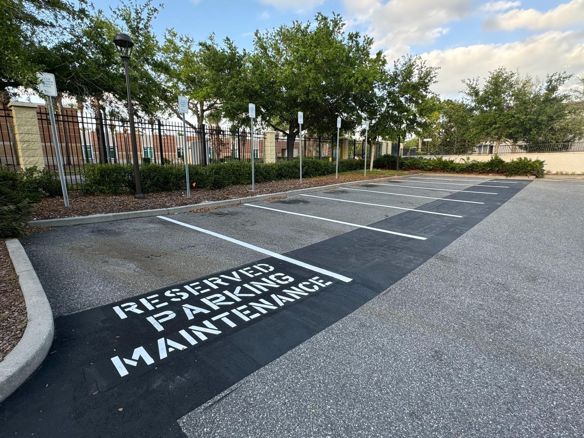 A man is pouring asphalt from a bucket onto a road.