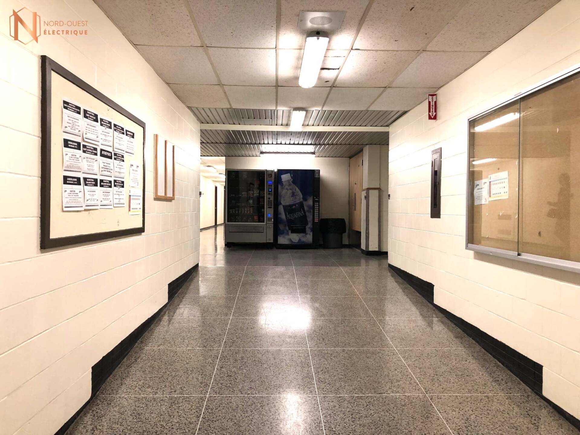Un long couloir avec un distributeur automatique au milieu