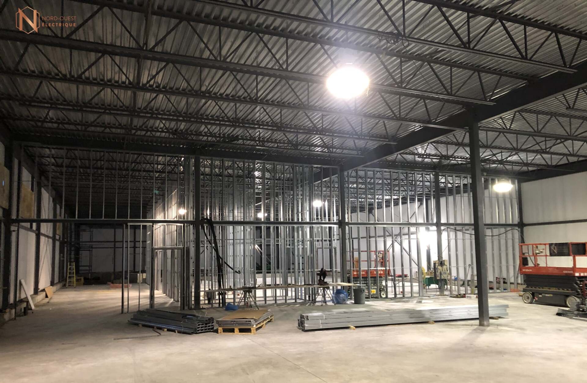 Un grand entrepôt en construction avec beaucoup de charpentes métalliques.