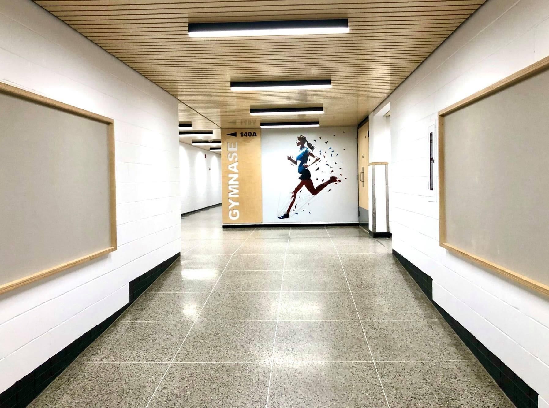 Un long couloir avec une photo d'une personne qui court sur le mur.