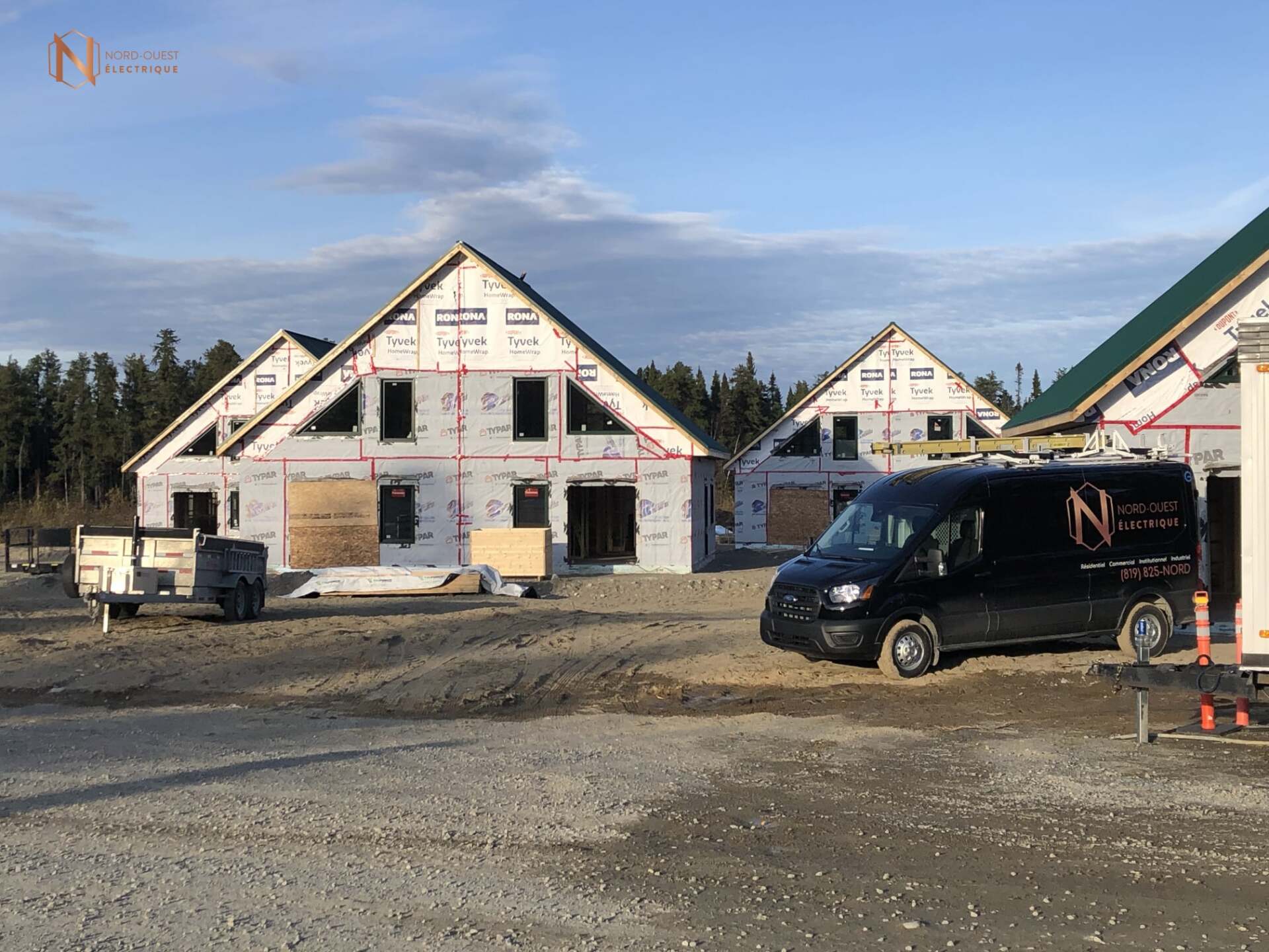 Une camionnette noire est garée devant un immeuble en construction.