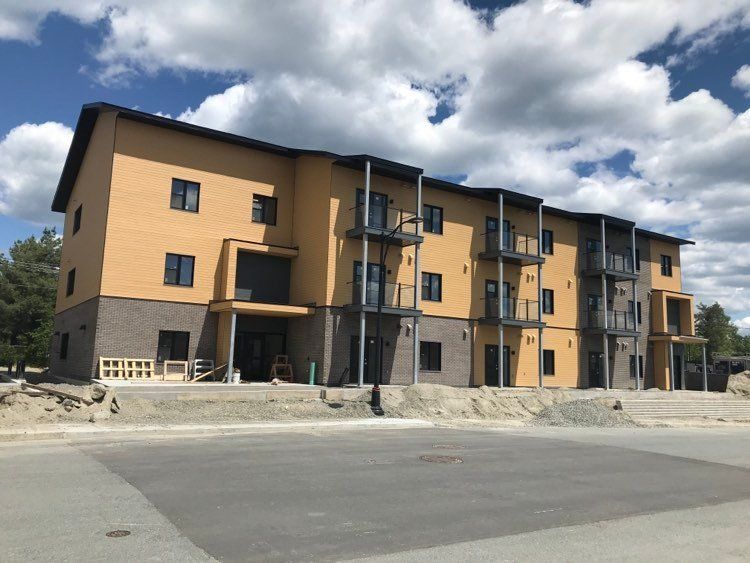 Un grand immeuble d'appartements avec beaucoup de fenêtres et de balcons