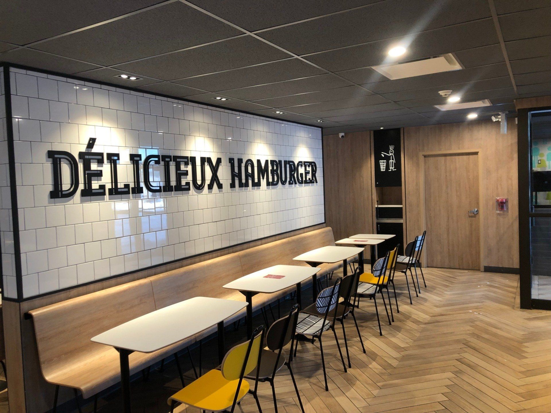 Un restaurant avec des tables et des chaises et un panneau indiquant délicieux hamburger