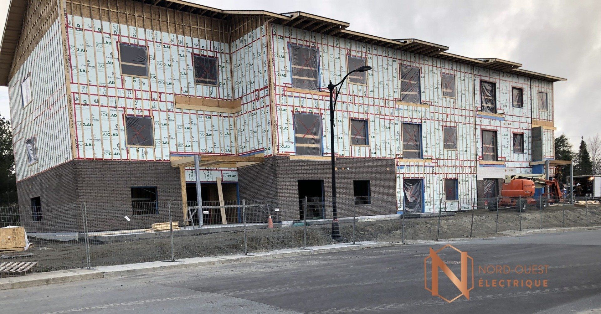 Un grand bâtiment est en construction au bord d'une route.