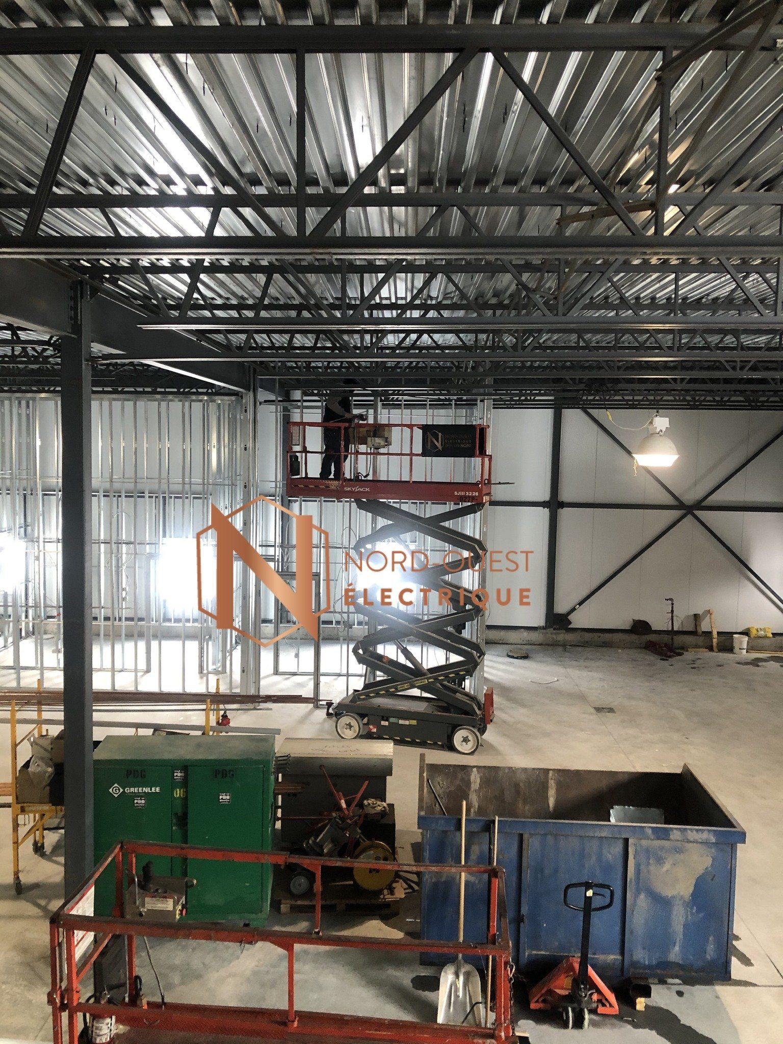 Un homme se tient debout sur une échelle dans un bâtiment en construction.