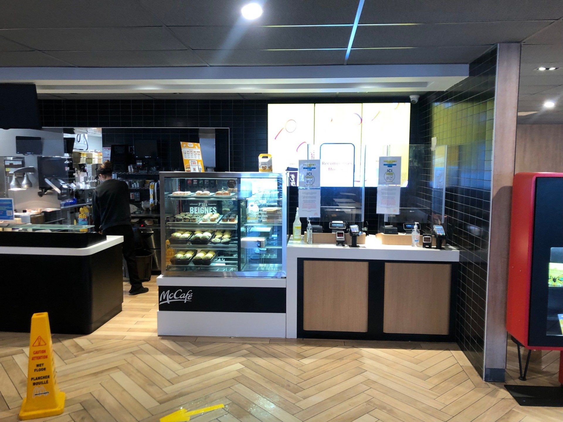 Un restaurant McDonald's avec un panneau d'avertissement jaune sur le sol