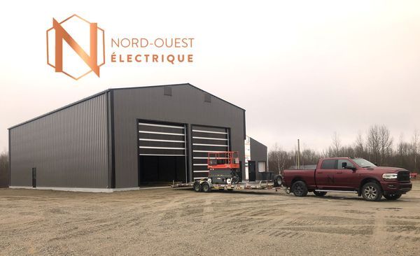 Un camion est garé devant un bâtiment sur lequel est écrit nord-quest electricque