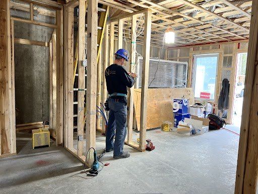 Un homme travaille sur un mur dans une pièce en construction.